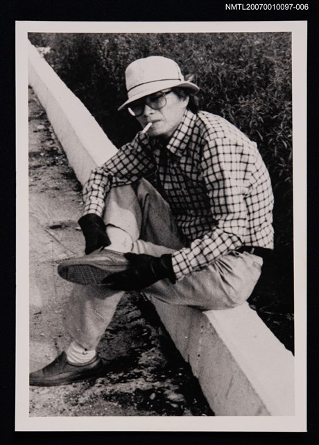 主要名稱：杜若洲獨照（坐於路邊圍欄上）（翻拍照）圖檔，第1張，共1張