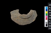 藏品(石環製作材料-中央帶啄孔與旋截痕打製圓板殘件)的圖片