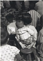 藏品(〈看戲〉：眾人坐於圓木椅上背影，中央一人揹小孩)的圖片