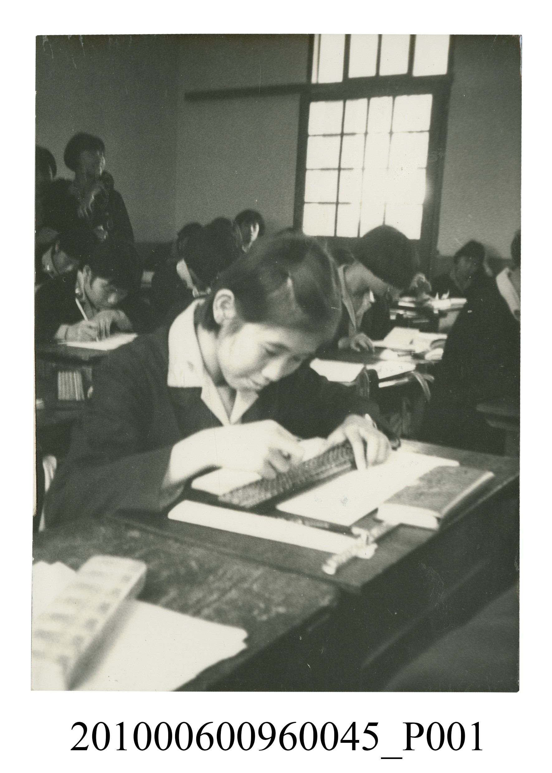 一女學生於教室座位上撥算盤之照片 (共2張)