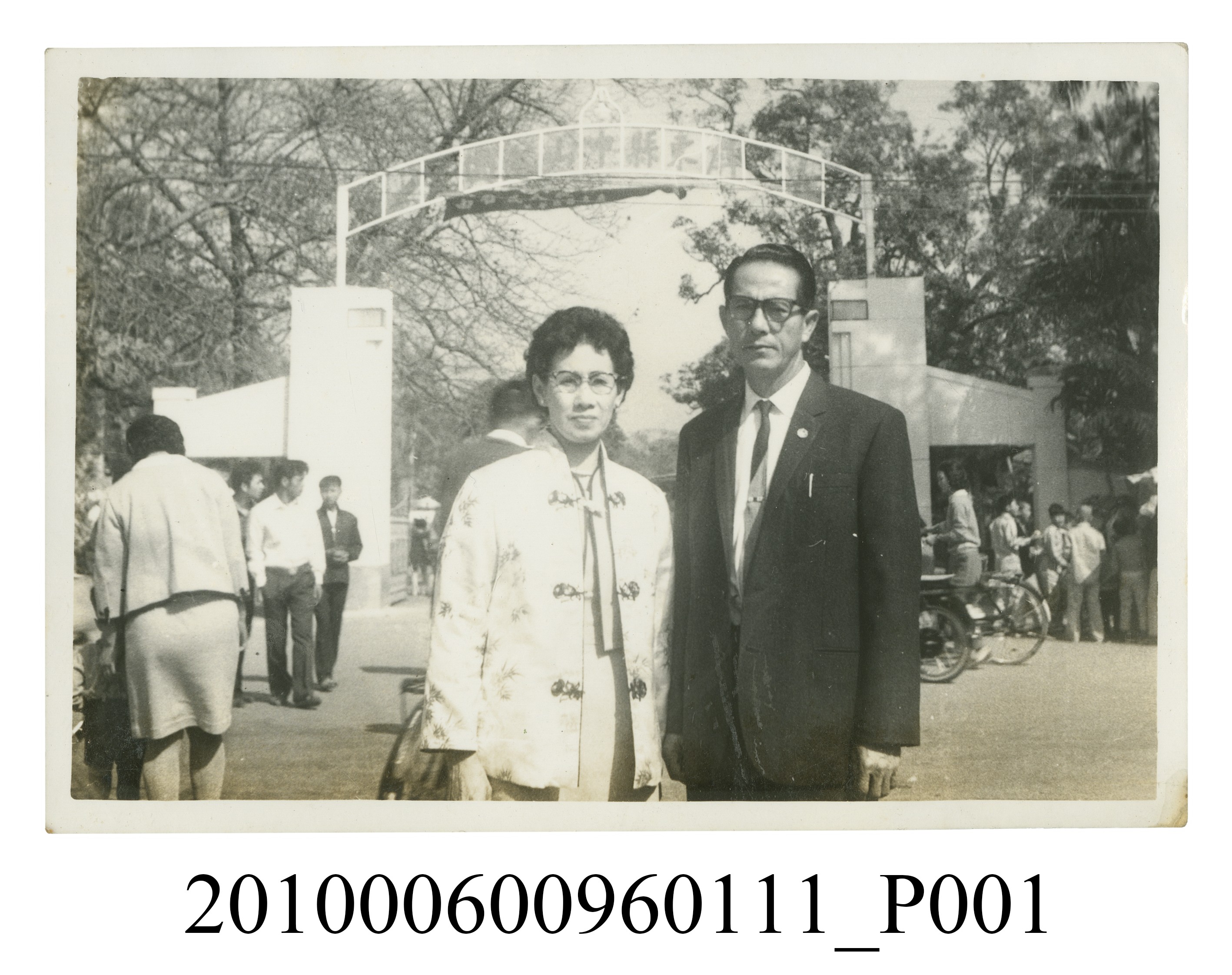 身穿西裝之男子與身穿唐裝之女子於屏東縣中山公園入口前合影之照片 (共2張)