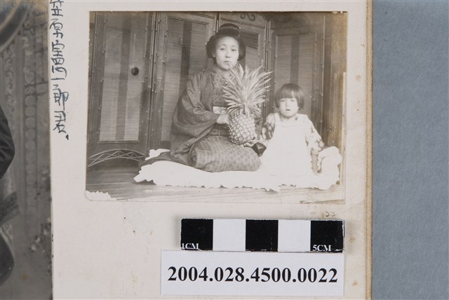 拿鳳梨成年女子與一名女童合照 (共2張)