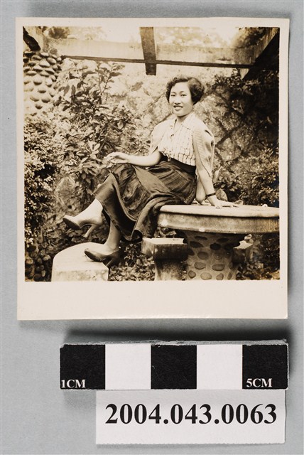 女子坐於石桌上獨照 (共2張)