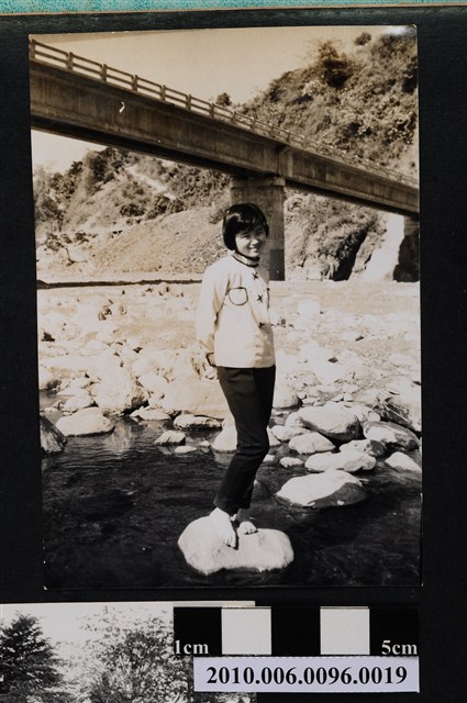 女子於橋墩下溪床流水邊石頭上獨影之照片 (共2張)