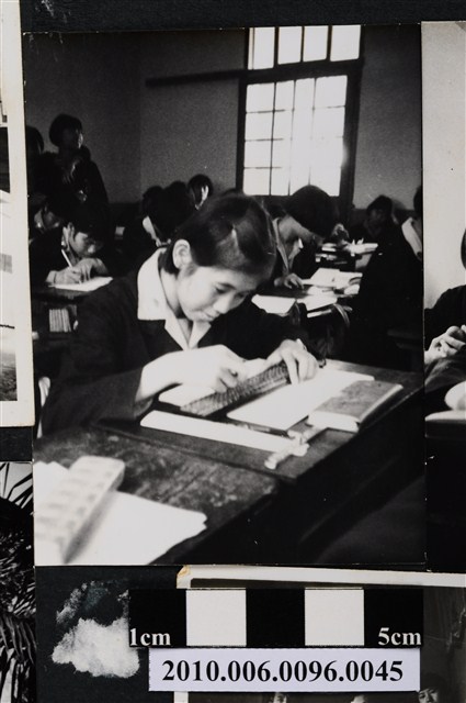 一女學生於教室座位上撥算盤之照片 (共2張)