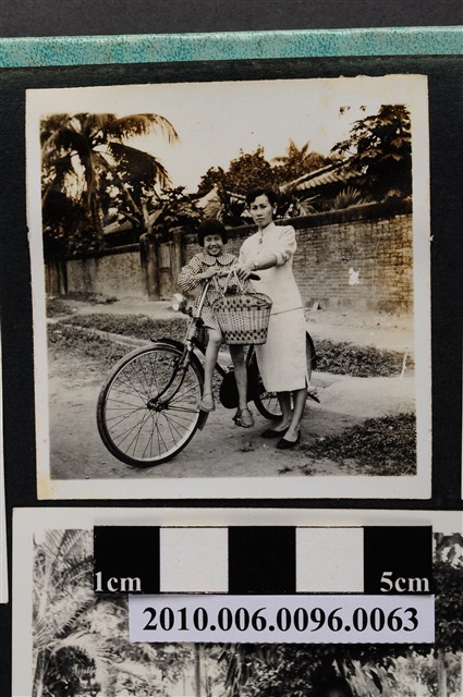 一婦人牽著一臺坐有女童的腳踏車合影之照片 (共2張)