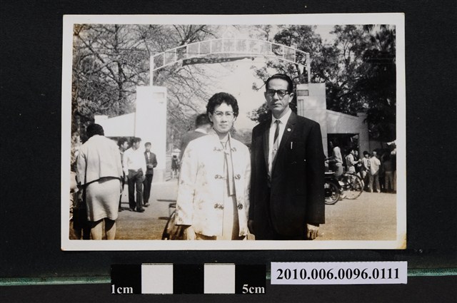 身穿西裝之男子與身穿唐裝之女子於屏東縣中山公園入口前合影之照片 (共2張)