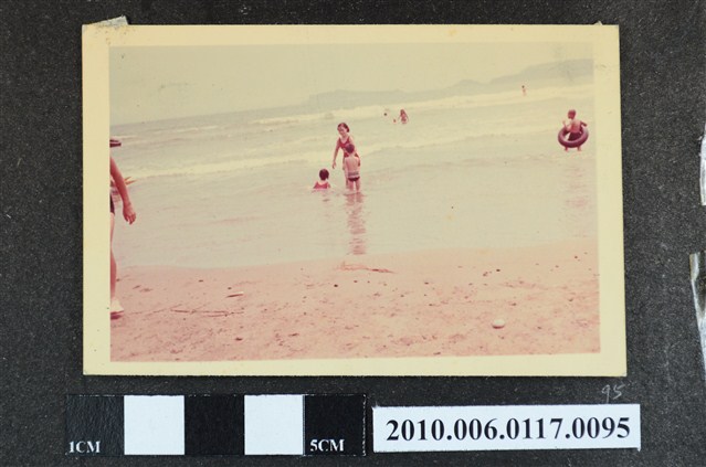 一女子與2位孩童在海邊戲水的照片 (共1張)