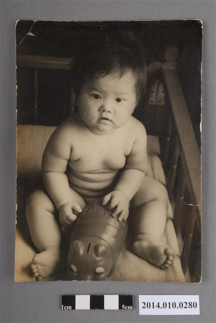 嬰兒車中把玩存錢筒玩具的孩童 (共2張)