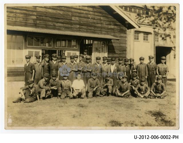 學生於機械工廠旁木造建築前著工作服合照藏品圖，第1張