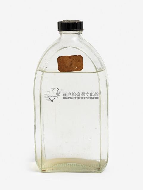 黑色塑膠帶蓋窄口短頸弧形透明玻璃扁瓶藏品圖，第1張