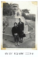 神社狛犬前的婦女藏品圖，第1張