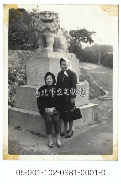 神社狛犬前的婦女藏品圖，第1張